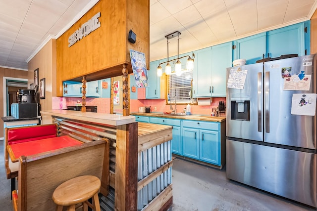 kitchen featuring sink, wooden counters, blue cabinets, stainless steel fridge with ice dispenser, and decorative light fixtures