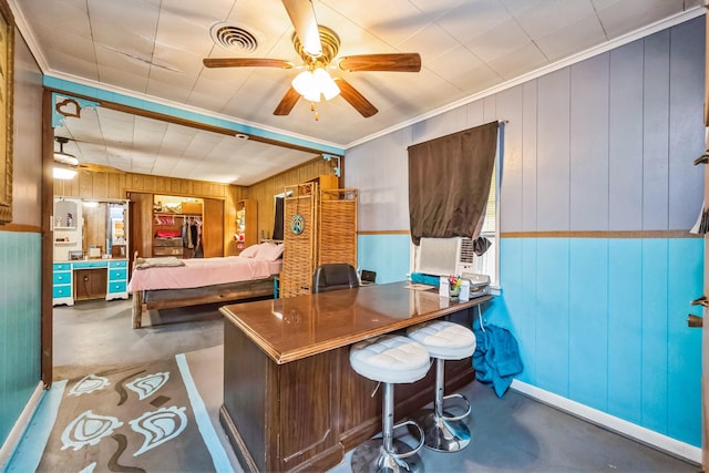 bedroom featuring ornamental molding, wooden walls, and ceiling fan