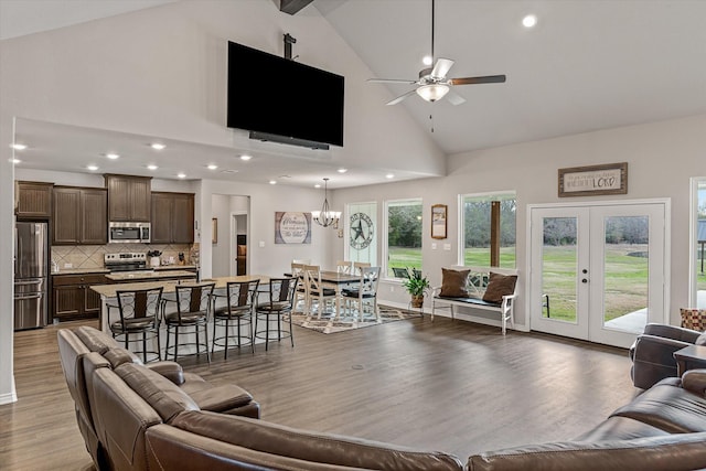 living room featuring ceiling fan with notable chandelier, beamed ceiling, french doors, high vaulted ceiling, and light hardwood / wood-style flooring