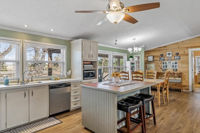 kitchen with white cabinetry, a breakfast bar area, a kitchen island, stainless steel dishwasher, and sink