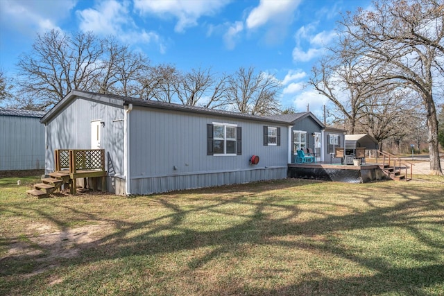 rear view of property featuring a wooden deck and a yard