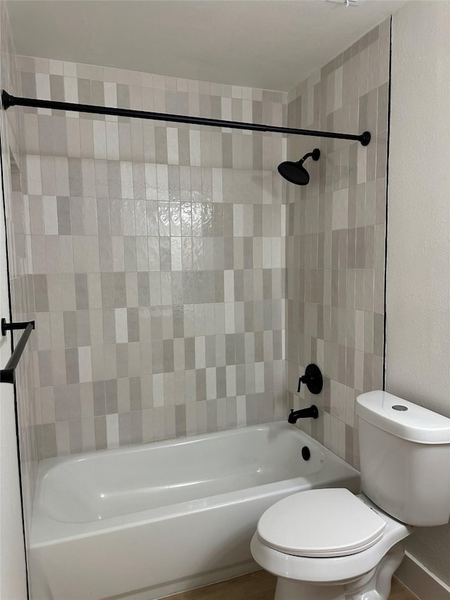 bathroom featuring toilet and tiled shower / bath combo