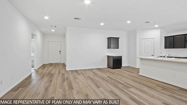 unfurnished living room with hardwood / wood-style floors and sink