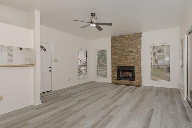 unfurnished living room featuring light wood-type flooring, ceiling fan, and a fireplace