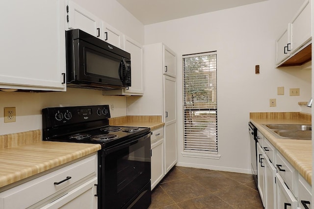 kitchen featuring sink, white cabinets, black appliances, and dark tile patterned floors