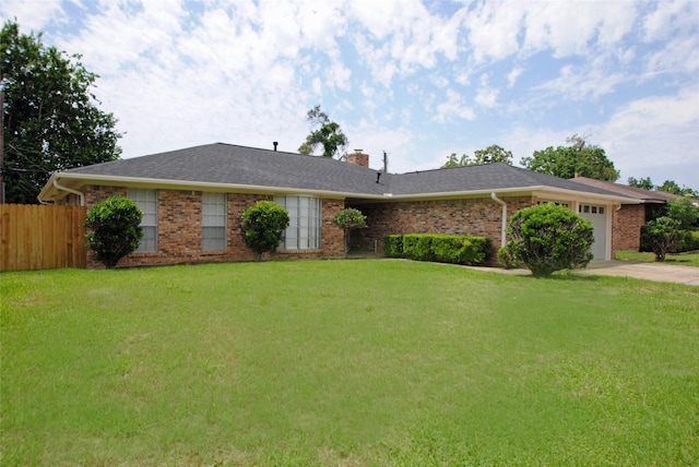 ranch-style house featuring a garage and a front lawn