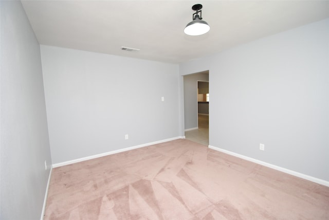 unfurnished room featuring light carpet