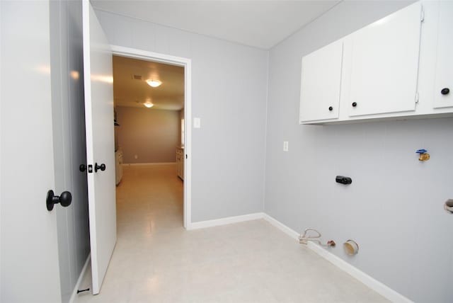 washroom with gas dryer hookup and cabinets