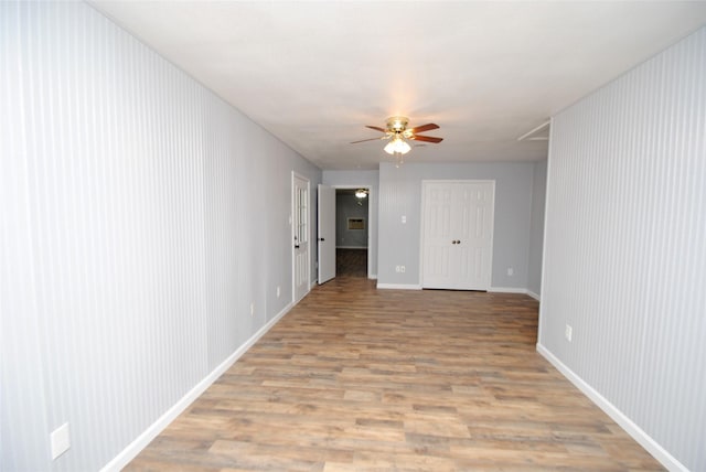 empty room with ceiling fan and light hardwood / wood-style flooring