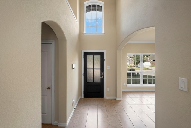 tiled foyer featuring ornamental molding