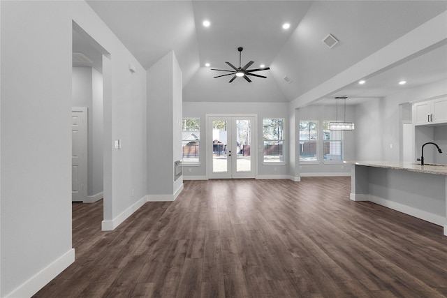 unfurnished living room featuring high vaulted ceiling, sink, dark hardwood / wood-style flooring, ceiling fan, and french doors