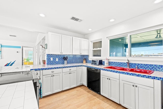 kitchen featuring a wealth of natural light, black dishwasher, white cabinets, and sink