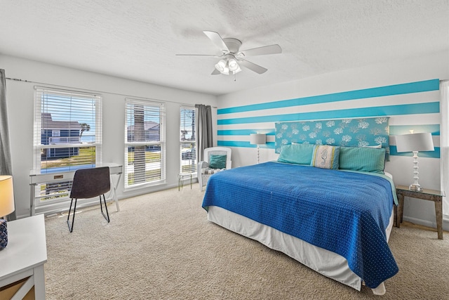 carpeted bedroom with ceiling fan and a textured ceiling