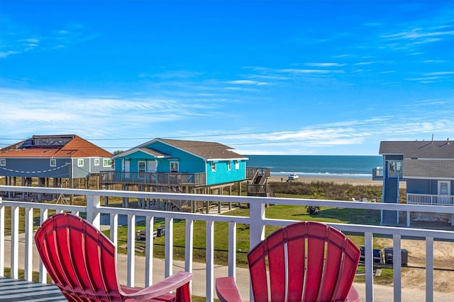 balcony with a water view and a view of the beach