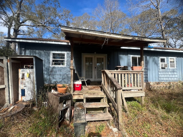 back of property featuring a wooden deck, gas water heater, and french doors