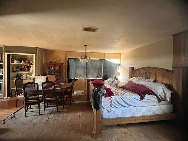 bedroom with dark wood-type flooring and an inviting chandelier