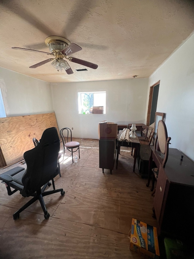 interior space featuring ceiling fan and a textured ceiling