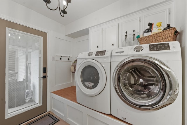 laundry area with cabinets, plenty of natural light, washing machine and dryer, and a notable chandelier