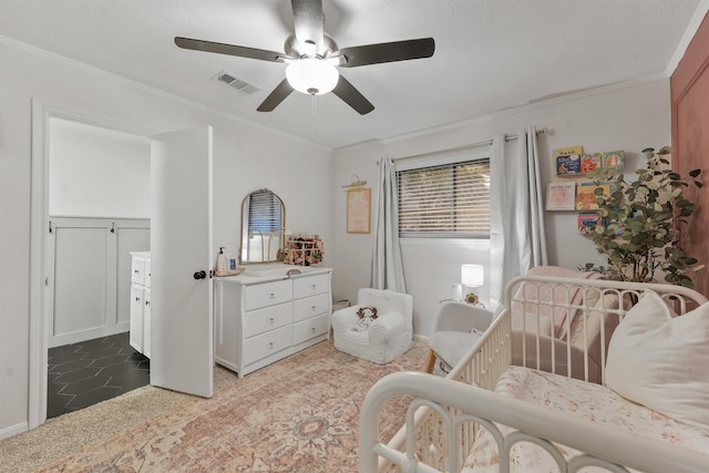 bedroom with crown molding, ceiling fan, and a crib