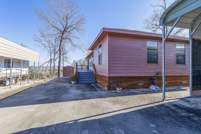 view of home's exterior with a carport and a storage shed