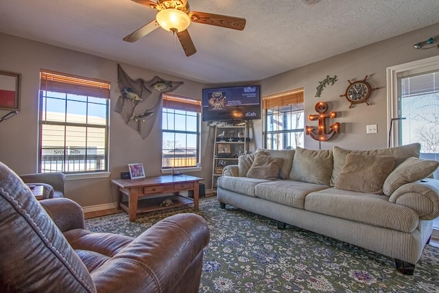 living room featuring ceiling fan and a textured ceiling