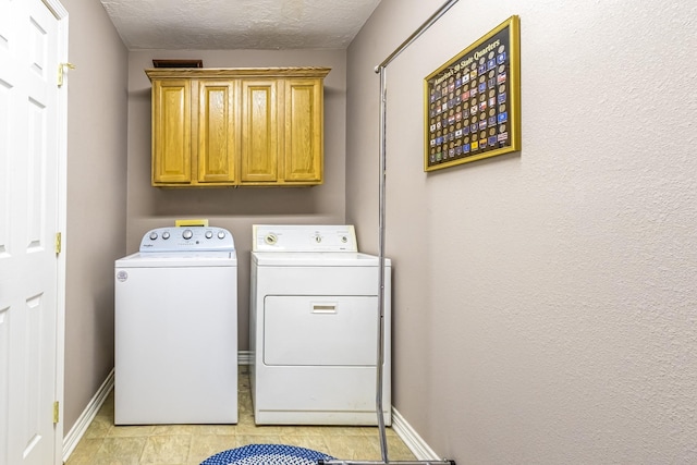 washroom featuring separate washer and dryer, a textured ceiling, and cabinets