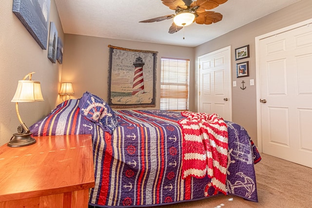 bedroom featuring ceiling fan and carpet