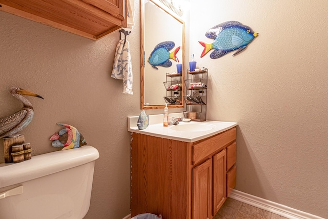 bathroom with toilet, tile patterned flooring, and vanity