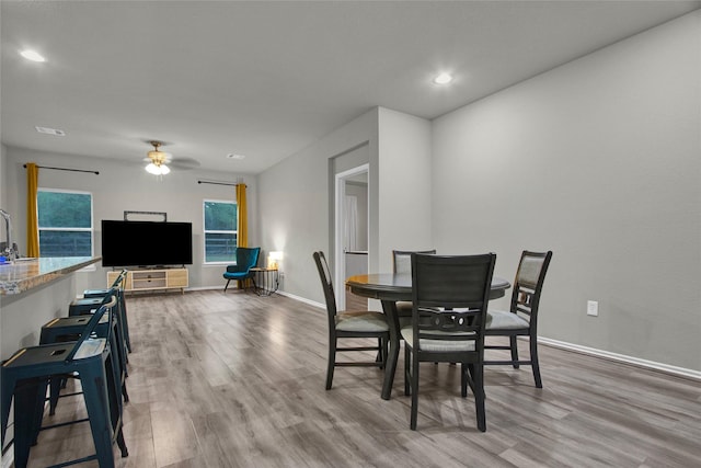 dining area with light hardwood / wood-style floors and ceiling fan