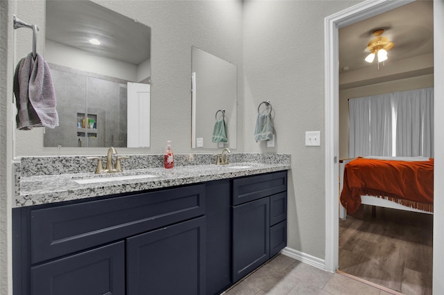 bathroom featuring walk in shower, vanity, tile patterned flooring, and ceiling fan