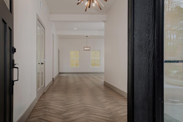 hall featuring parquet flooring and a chandelier