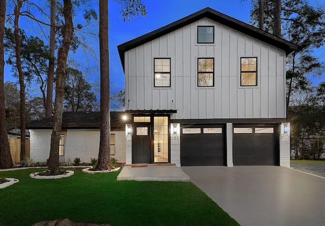 modern farmhouse featuring a lawn and a garage