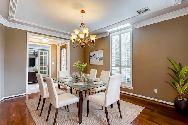 dining room featuring dark wood-type flooring, crown molding, and a chandelier