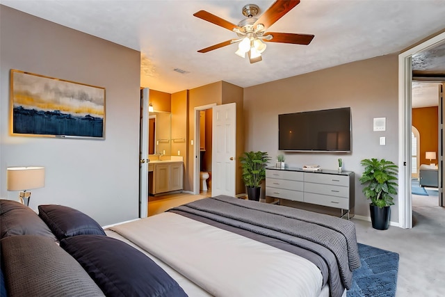 carpeted bedroom featuring ceiling fan and ensuite bathroom