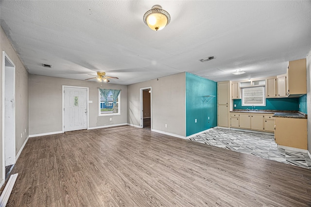 interior space featuring ceiling fan, a textured ceiling, and light hardwood / wood-style floors