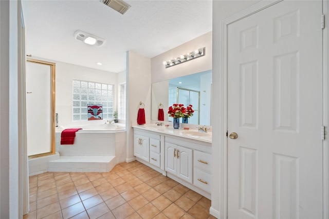 bathroom with separate shower and tub, vanity, tile patterned flooring, and a textured ceiling