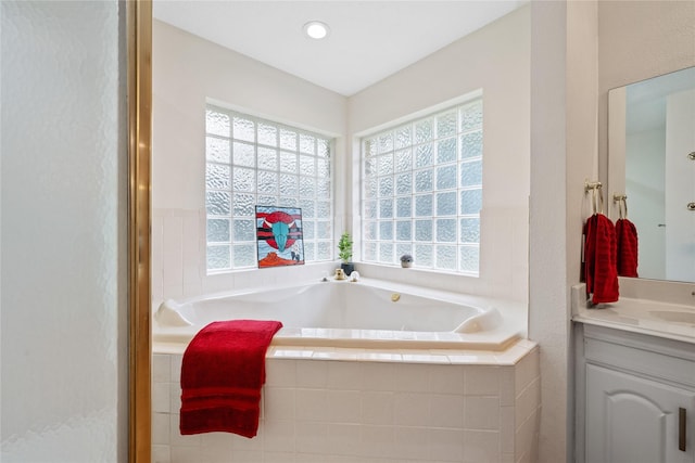 bathroom featuring tiled bath and vanity