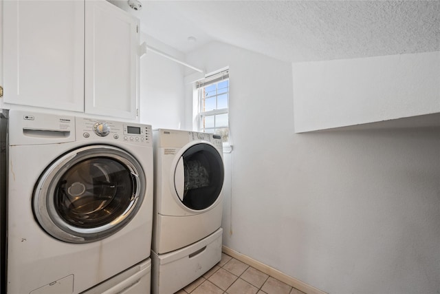 washroom featuring cabinets, a textured ceiling, light tile patterned floors, and independent washer and dryer