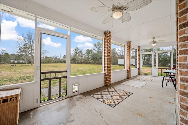 unfurnished sunroom with ceiling fan and a wealth of natural light