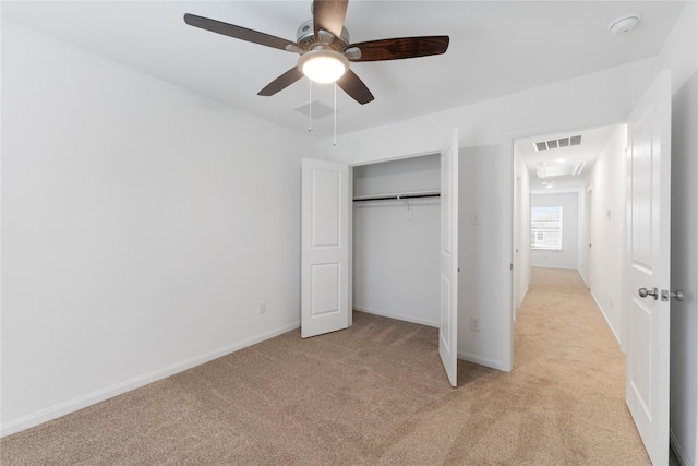 unfurnished bedroom with light carpet, ceiling fan, and a closet