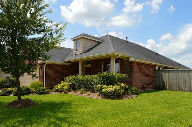 view of side of home with a yard