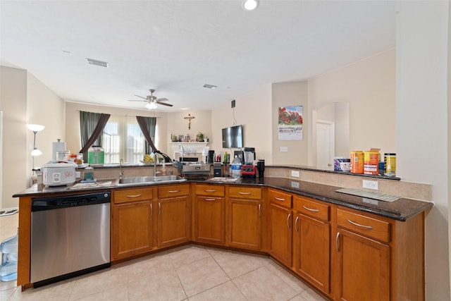 kitchen with sink, dark stone countertops, light tile patterned floors, dishwasher, and kitchen peninsula