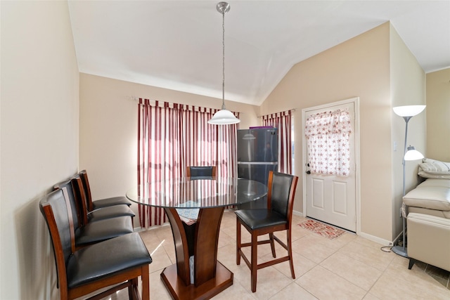 tiled dining space featuring lofted ceiling