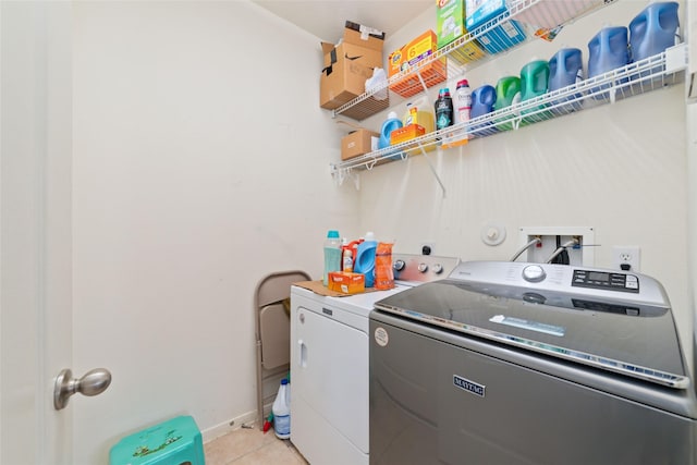 clothes washing area with separate washer and dryer and light tile patterned floors