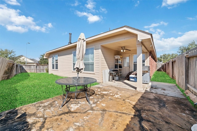 back of property featuring ceiling fan, a yard, and a patio