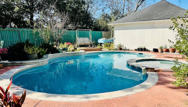 view of swimming pool with an in ground hot tub