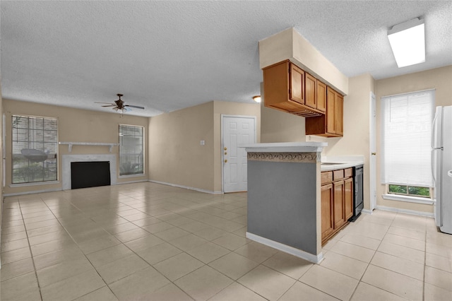 kitchen with ceiling fan, dishwasher, white fridge, light tile patterned flooring, and a textured ceiling