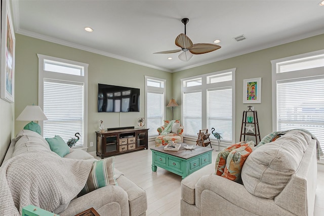 living room featuring ceiling fan, ornamental molding, and light wood-type flooring