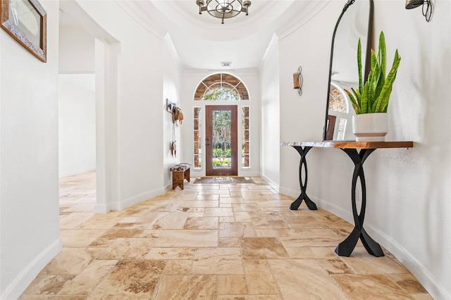 entryway with crown molding and a raised ceiling