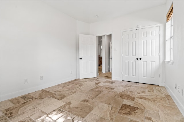 unfurnished bedroom featuring multiple windows and a closet